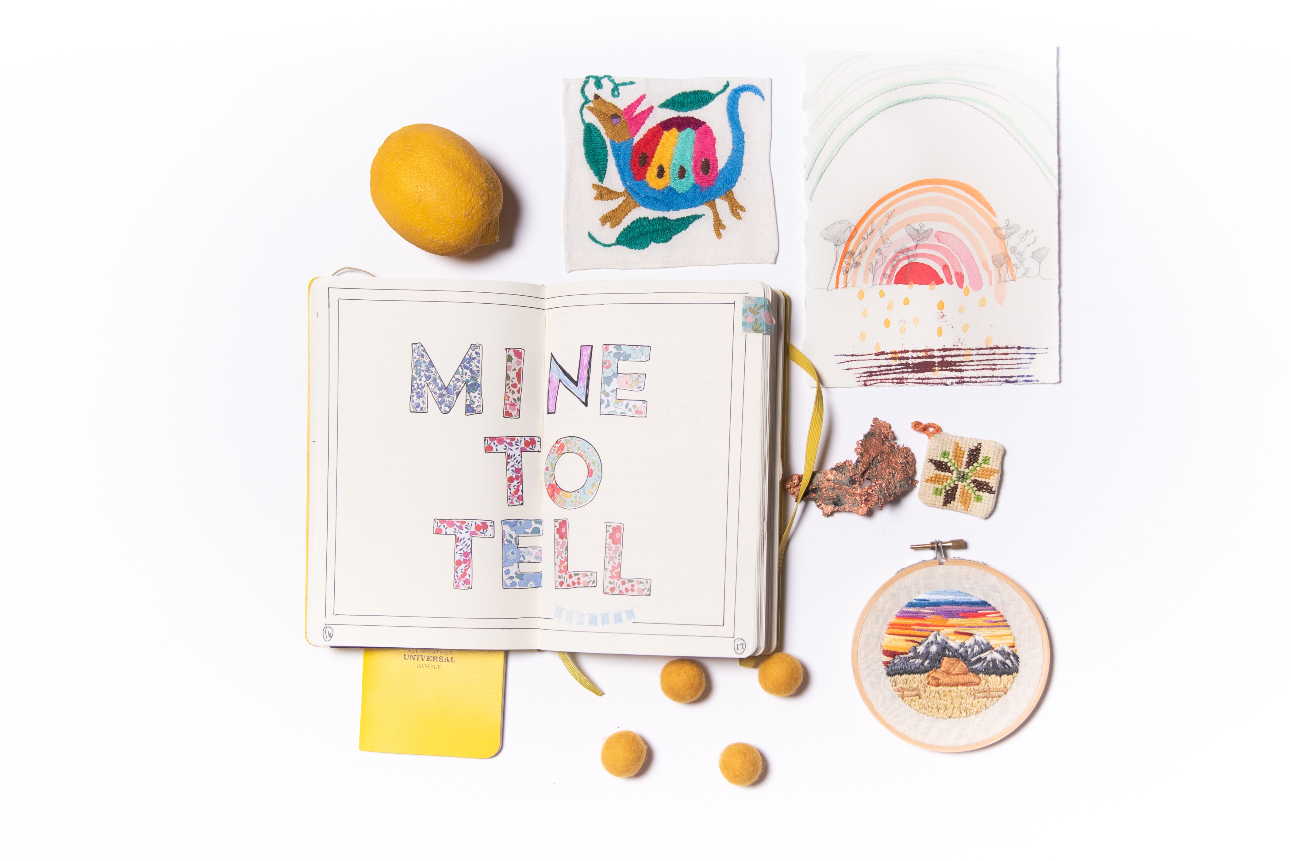 Yellow notebook surrounded by drawings and craft items